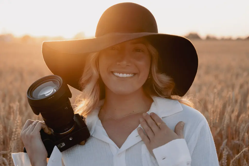 Kelly Deraps qui sourit avec un appareil photo dans les mains