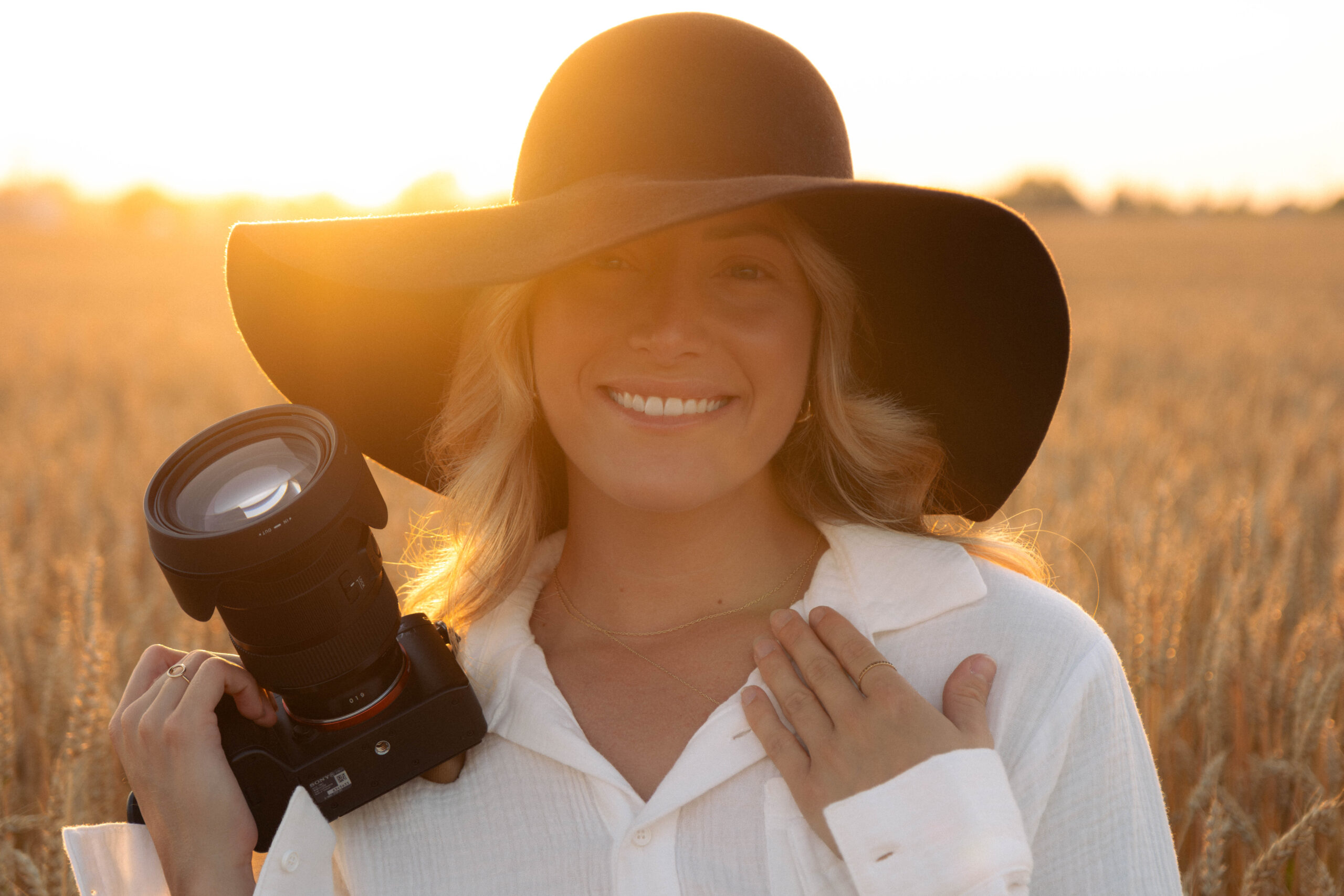 Kelly Deraps qui sourit avec un appareil photo dans les mains
